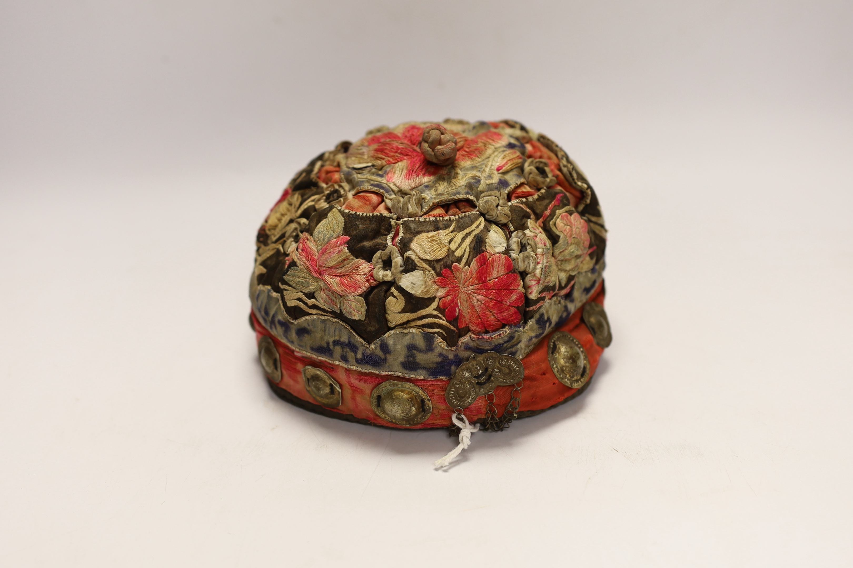 A Chinese metal mounted and embroidered skull cap